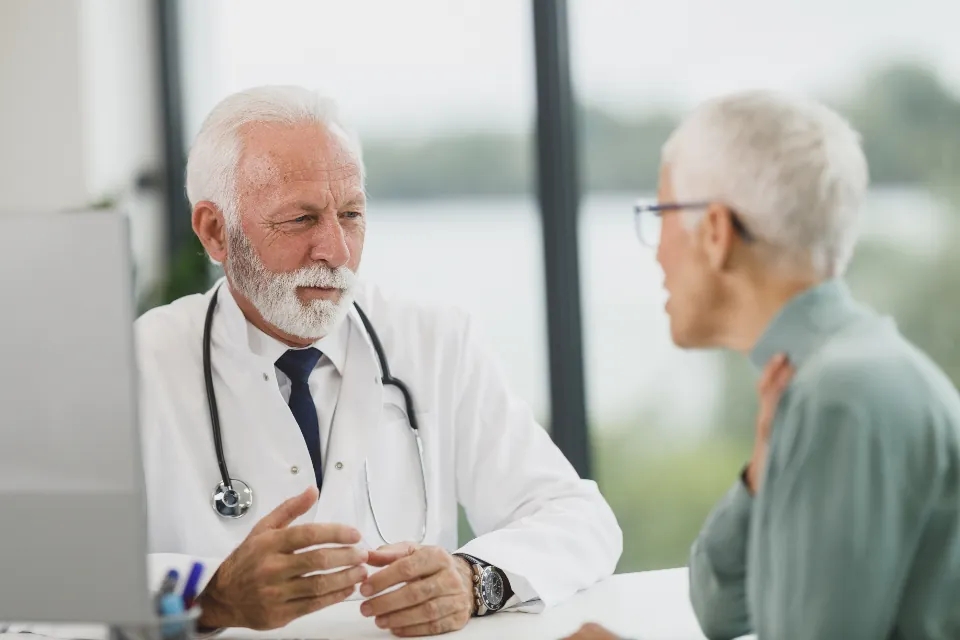 A doctor talking with a patient in a bright consulting room (stock photograph of models)